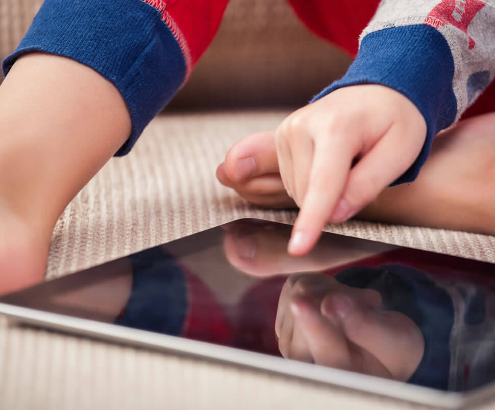 Enfant surfant sur internet sur une tablette tactile.