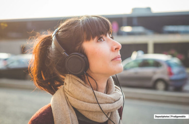 Comment mettre de la musique sur un iPhone Femme écoutant des fichiers MP3 sur son iPhone avec un casque audio
